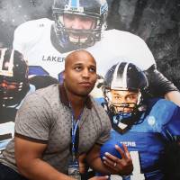 Guest holding a football, posing against a backdrop at the Jamie Hosford Football Center dedication.